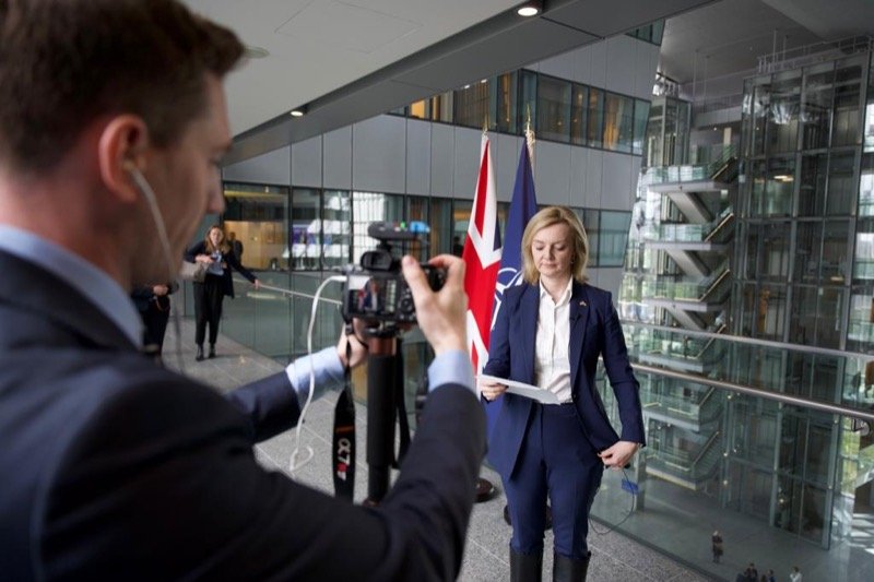 Robert Midgley filming the Foreign Secretary in front of Union and NATO flags