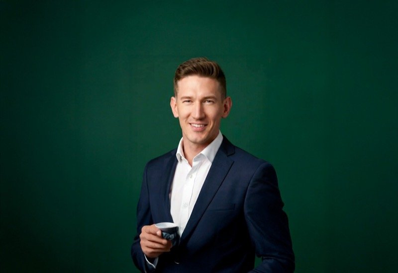 Studio portrait of Robert Midgley against a dark green backdrop
